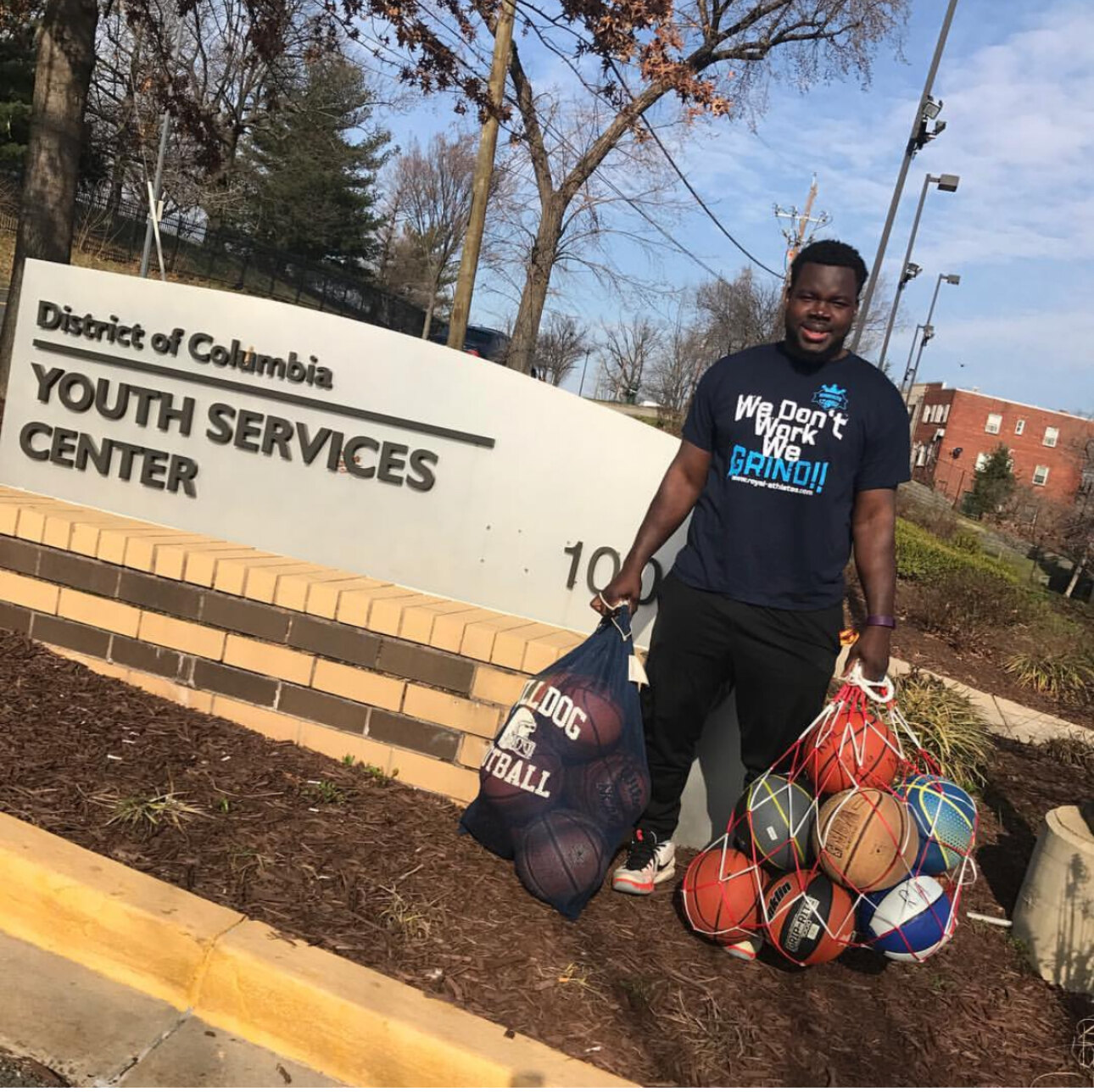 Royal Athletes coach with bags of basketballs in front of the District of Columbia Youth Services Center